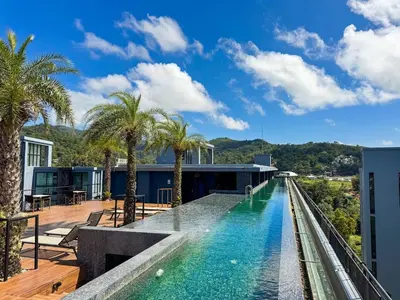 a swimming pool with palm trees on a building at Popular Kamala City Gate 1 bdr 3 Pools in Kamala Beach