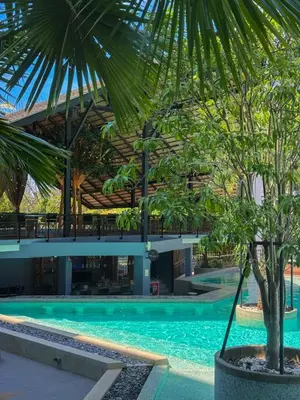 a building with a pool and a palm tree at Popular Kamala City Gate 1 bdr 3 Pools in Kamala Beach
