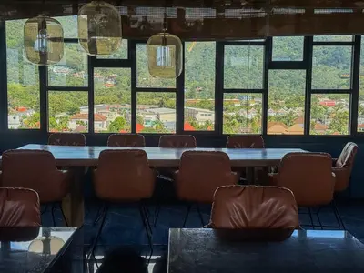 a large table and chairs in a room with windows at Cozy 1 Bdr City Gate Kamala Beach in Kamala Beach