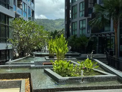 a courtyard with water fountains in the middle of buildings at Cozy 1 Bdr City Gate Kamala Beach in Kamala Beach