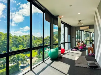 a room with large windows with people sitting on the floor at Cozy 1 Bdr City Gate Kamala Beach in Kamala Beach
