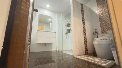 a bathroom with a toilet and a glass shower at Family House Patong - Homestay in Patong Beach