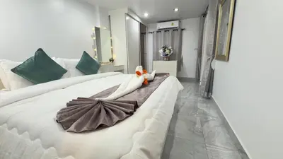 a large white bed with a stuffed animal on it at Family House Patong - Homestay in Patong Beach