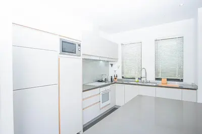 a white kitchen with white cabinets and a microwave at Luxury Pool Villa a Short Walk from Bangtao Beach in Bang Tao Beach