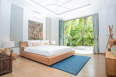 a bedroom with a bed and a large window at Luxury Pool Villa a Short Walk from Bangtao Beach in Bang Tao Beach