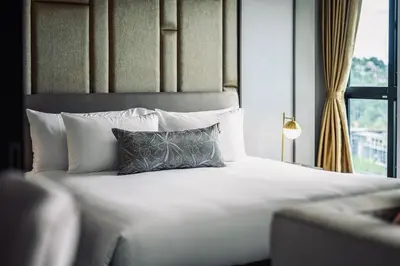 a bedroom with a bed with a pillow and a window at Private Villa at Mida Grande Resort in Surin Beach