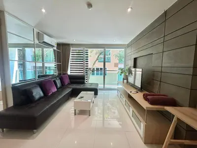 a living room with a black couch and a tv at The Bay Cliff Kalim 1 Large Bedroom by ALL HOMES in Patong Beach