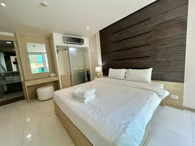 a bedroom with a large bed with a wooden headboard at The Bay Cliff Kalim 1 Large Bedroom by ALL HOMES in Patong Beach