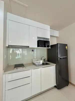 a kitchen with white cabinets and a black refrigerator at The Bay Cliff Kalim 1 Large Bedroom by ALL HOMES in Patong Beach
