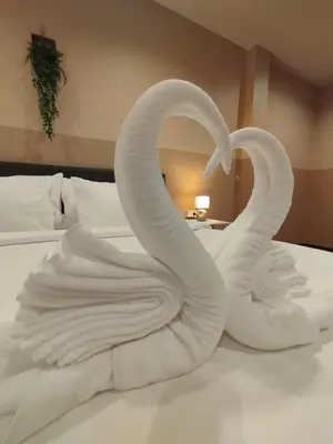 two swans made out of towels on a bed at SSS Room Patong in Patong Beach