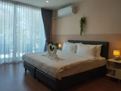 a bedroom with a bed with two swans on it at SSS Room Patong in Patong Beach