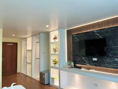a living room with a flat screen tv on a wall at SSS Room Patong in Patong Beach