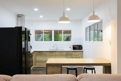 a kitchen with a wooden table and a counter top at 2,5BR Tropical Lakeview Villa I Bangtao Beach in Surin Beach