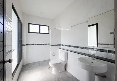 a white bathroom with a toilet and a sink at Nua Tone Pool Villa I Mountain View I Bangtao Beach in Ban Thalat Choeng Thale