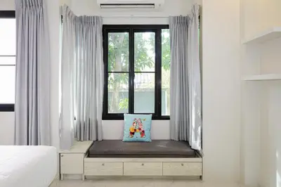 a window seat in a bedroom with a bed and a pillow at Nua Tone Pool Villa I Mountain View I Bangtao Beach in Ban Thalat Choeng Thale