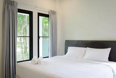 a bedroom with a bed with two white towels on it at Nua Tone Pool Villa I Mountain View I Bangtao Beach in Ban Thalat Choeng Thale