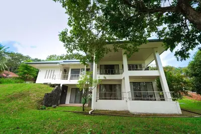 a white house with a tree in front of it at Blue Canyon Golf and Country Club Villa 97 in Ban Muang Mai (1)