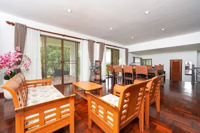 a dining room with wooden chairs and a dining table at Blue Canyon Golf and Country Club Villa 97 in Ban Muang Mai (1)