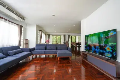 a living room with blue couches and a large flat screen tv at Blue Canyon Golf and Country Club Villa 97 in Ban Muang Mai (1)