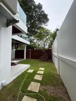 a backyard with a garden hose on the grass at Cozy Siray Phuket 3-Floor Seaview Family Home in Ban Lo Ti Pa (1)