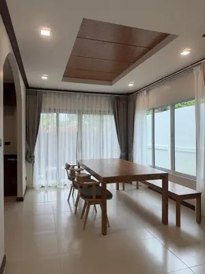 a dining room with a table and chairs and windows at Cozy Siray Phuket 3-Floor Seaview Family Home in Ban Lo Ti Pa (1)