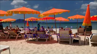 a group of chairs and umbrellas on a beach at xx Bao Patong Beach - Phuket Island in Patong Beach