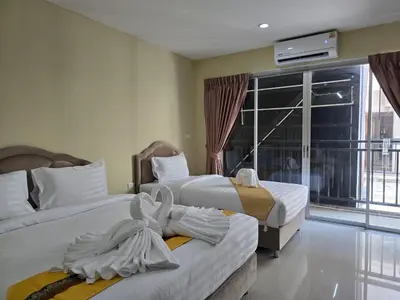 a hotel room with two beds and a balcony at Blue Sapphire Hotel in Patong Beach