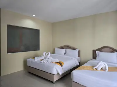two beds in a hotel room with towels on them at Blue Sapphire Hotel in Patong Beach