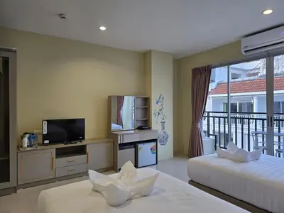 a hotel room with two beds and a television at Blue Sapphire Hotel in Patong Beach