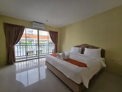 a bedroom with a bed and a large window at Blue Sapphire Hotel in Patong Beach