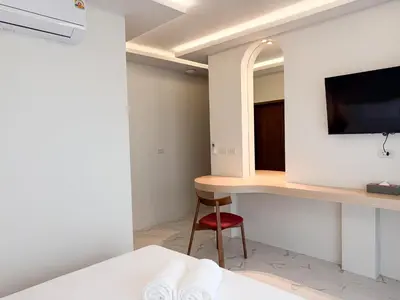a bedroom with a desk and a mirror and a bed at Laoteng Boutique Hotel in Phuket Town