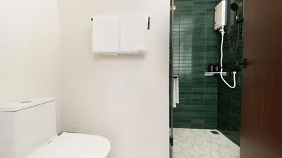 a bathroom with a green tiled shower with a toilet at Laoteng Boutique Hotel in Phuket Town