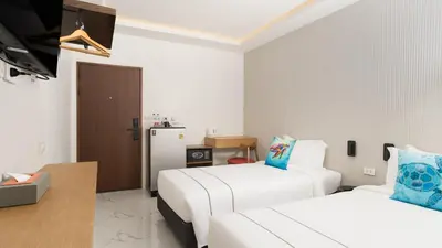 a hotel room with two beds and a television at Laoteng Boutique Hotel in Phuket Town