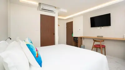 a hotel room with a bed and a television at Laoteng Boutique Hotel in Phuket Town