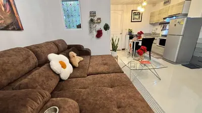 a living room with a brown couch with stuffed animals on it at 209 Patong loft condominium in Patong Beach