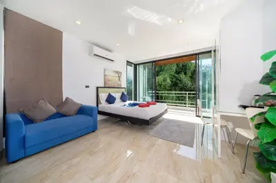 a living room with a blue couch and a table at 3-Story Pool Villa Near Kata Beach - UTK 4 in Kata Beach
