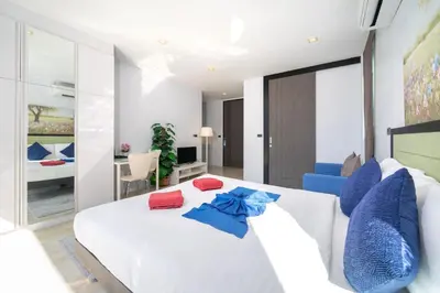a bedroom with a white bed with red and blue pillows at 3-Story Pool Villa Near Kata Beach - UTK 4 in Kata Beach