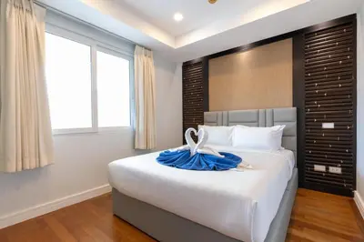 a bedroom with a large bed with a blue dress on it at Sea view apartment at Bel Air Panwa in Ban Ao Makham