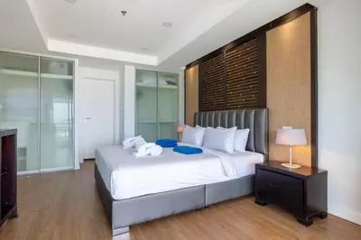 a bedroom with a large white bed and a television at Sea view apartment at Bel Air Panwa in Ban Ao Makham