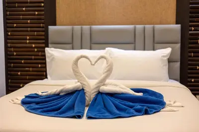 two swans made out of towels on a bed at Sea view apartment at Bel Air Panwa in Ban Ao Makham
