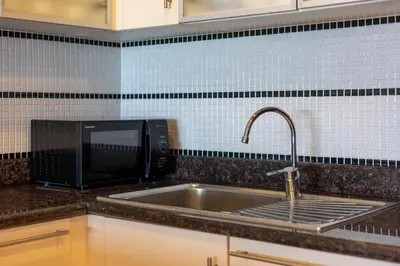 a kitchen counter with a sink and a microwave at Sea view apartment at Bel Air Panwa in Ban Ao Makham