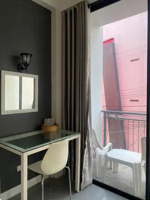 a desk and a chair in a room with a window at Arch Club in Patong Beach