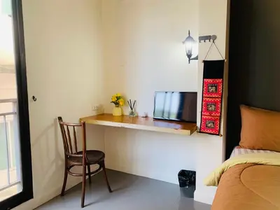 a bedroom with a desk and a bed with a laptop at Arch Club in Patong Beach