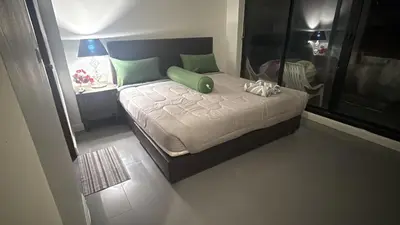 a bedroom with a bed with a green pillow on it at Arch Club in Patong Beach