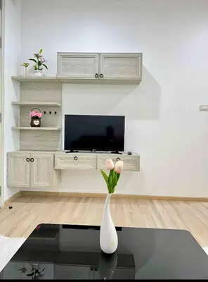 a living room with a vase with flowers in it at Elegant Stay with 360 degree Panoramic Rooftop Pool in Ban Sam Kong
