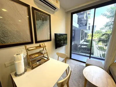 a living room with a table and a large window at Private apartment at Skypark in Laguna by Lofty in Laguna Phuket