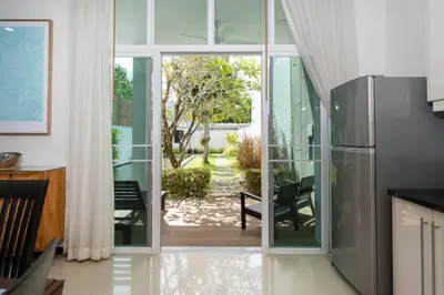 a kitchen with a sliding glass door leading to a patio at Tropical retreat-pool villa at Oxygen Bangtao in Ban Thalat Choeng Thale