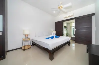 a bedroom with a bed and a ceiling fan at Tropical retreat-pool villa at Oxygen Bangtao in Ban Thalat Choeng Thale