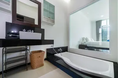 a bathroom with a large mirror and a bath tub at Tropical retreat-pool villa at Oxygen Bangtao in Ban Thalat Choeng Thale