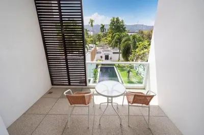 a balcony with a table and three chairs and a window at Tropical retreat-pool villa at Oxygen Bangtao in Ban Thalat Choeng Thale